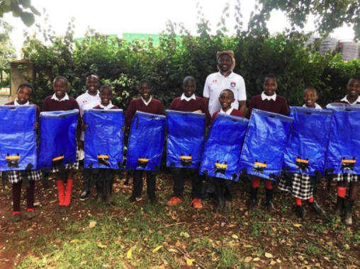 Dr. Peter G. Kirira distributes water backpacks to primary school children in Laikipia County